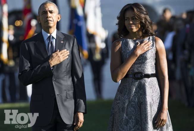 US President Barack Obama and First Lady Michelle Obama stand on the South Lawn of the White House in Washington, DC, September 11, 2015, to mark the 14th anniversary of the 9/11 attacks on the United States. AFP PHOTO / SAUL LOEB