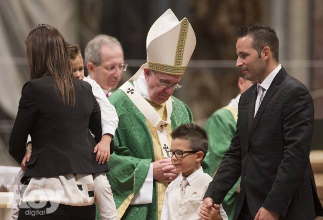 Una familia tras entregar ofrendas al papa Francisco durante la mia que abrió el sínodo de obispos, en la basílica de San Pedro del Vaticano, el 4 de octubre de 2015. (Foto AP/Alessandra Tarantino)