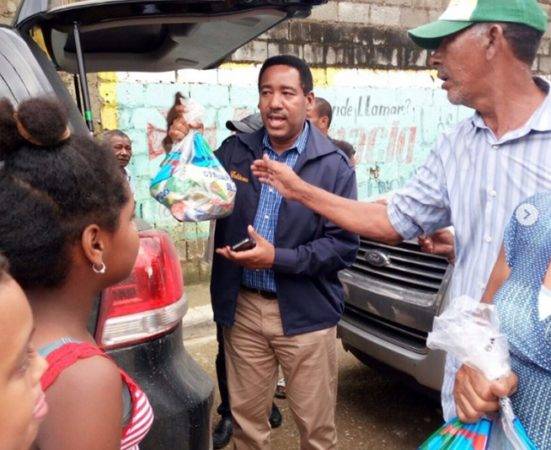 El administrador general de los Comedores Nicolás Calderón hace entrega de alimentos en el sector Los Dominguez de Puerto Plata.