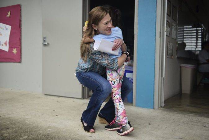 La secretaria de Educación Julia Keleher recibe un abrazo de una alumna en la escuela primaria Ramón Marín Solá, que abrió sus puertas como centro comunitario de día tras el paso del huracán María en Guaynabo, Puerto Rico.AP 