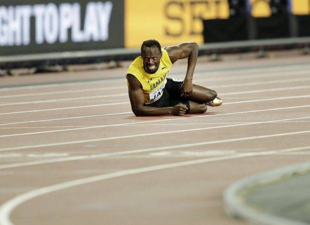 El velocista jamaiquino Usain Bolt aparece tirado en el suelo tras lesionarse en la final de los 4x100 metros en el Mundial de Atletismo en Londres.