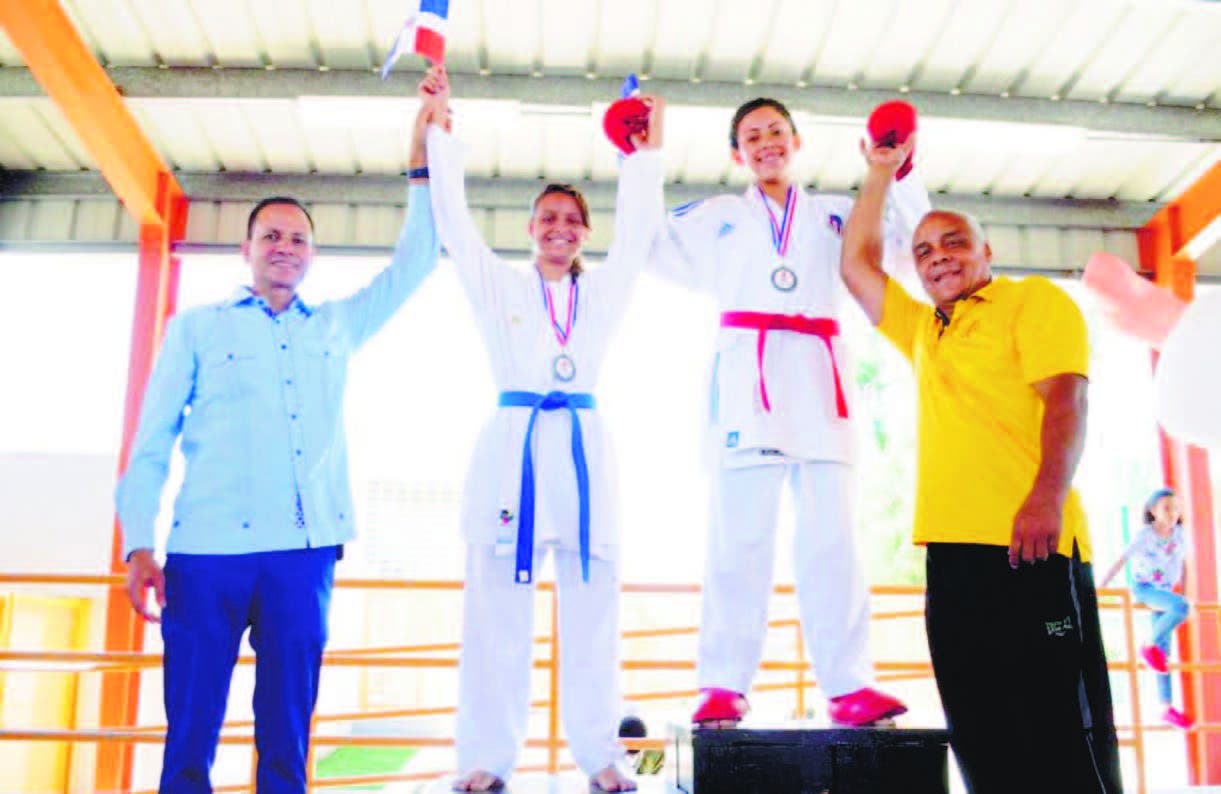 Edi Medina (izquierda) premia a Darialaris Ortiz y Nicole Morales, ganadoras de oro y plata en el karate.