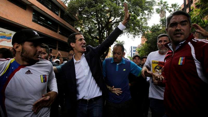 Juan Guaido, head of Venezuela's opposition-run congress, waves at supporters after declaring himself interim president of the South American country, during a rally demanding the resignation of President Nicolas Maduro, in Caracas, Venezuela, Wednesday, Jan. 23, 2019. (AP Photo/Boris Vergara)