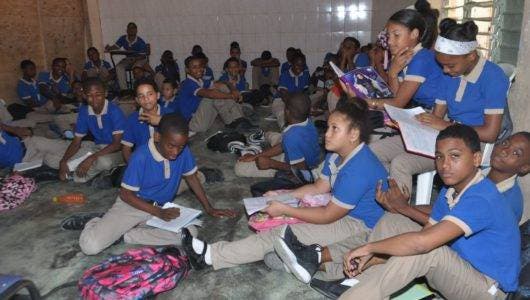 Cientos reciben clases   en piso por falta  butacas en el 13 Las Américas