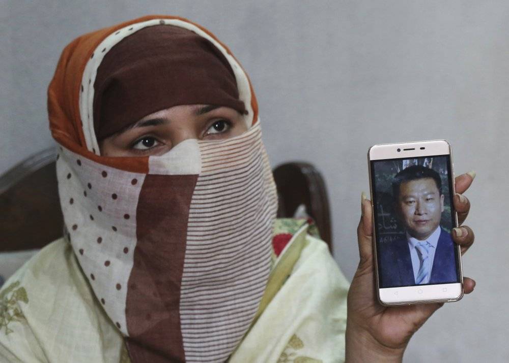 Sumaira muestra una foto del chino con que se casó. La mujer, quien no quiso dar su apellido, dice que fue violada reiteradamente por chinos en una casa de Islamabad, Pakistán, luego de que sus hermanos arreglasen su matrimonio con un chino mayor que ella. Foto tomada el 22 de mayo del 2019 en Gujranwala, Pakistán. (AP Photo/K.M. Chaudary, File).