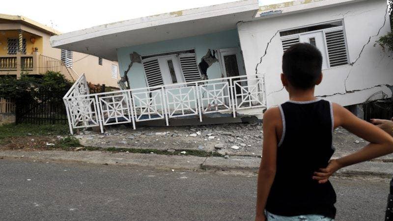  Un niño observa una casa dañada por el temblor de magnitud 5,8 que se reportó este lunes a las 06.32 hora local (10.32 GMT) en la costa de Guánica, municipio del suroeste de Puerto Rico. Cerca de 200.000 viviendas en Puerto Rico construidas sin los permisos requeridos están expuestas a las consecuencias de los terremotos que estos días sacuden a la isla caribeña, que este lunes sufrió un sismo de magnitud 5,8. EFE/ Thais Llorca