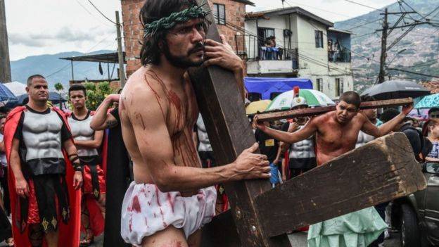 Las representaciones del calvario de Cristo cargando la cruz se repiten en varios puntos del planeta. Esta recreación es del jueves santo en Medellín, Colombia. 