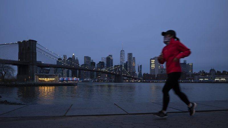 Una mujer corre protegida por una máscara en el Brooklyn Bridge Park en Nueva York el martes, 14 de abril del 2020. (AP Foto/Mark Lennihan)