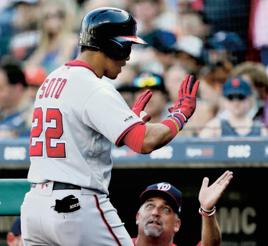 Washington Nationals' Juan Soto (22) is congratulated by pitching coach Paul Menhart after hitting a solo home run against the Detroit Tigers during the second inning of a baseball game, Friday, June 28, 2019, in Detroit. (AP Photo/Duane Burleson)