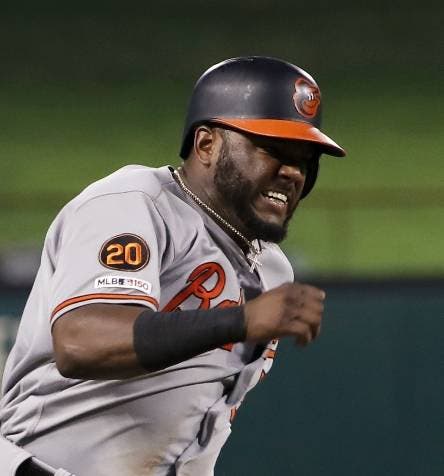 Baltimore Orioles third base coach Jose David Flores (11) waves Hanser Alberto home as Alberto scores on a Chris Davis double during the sixth inning of a baseball game against the Texas Rangers in Arlington, Texas, Thursday, June 6, 2019. (AP Photo/Tony Gutierrez