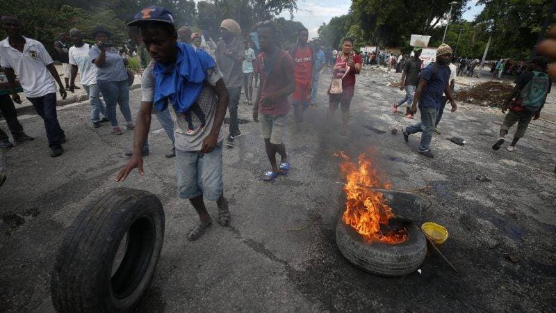 Protestors calling for the resignation of Haitian President Jovenel Moise burn tires in a park outside the National Palace in Port-au-Prince, Haiti, Tuesday, Oct. 1, 2019. While there were sporadic demonstrations on Tuesday, another protest scheduled for Wednesday threatened to once again paralyze Haiti's capital and nearby communities, which have endured violent demonstrations for nearly a month as anger grows over corruption, spiraling inflation and dwindling supplies of food and gasoline. (AP Photo/Rebecca Blackwell)