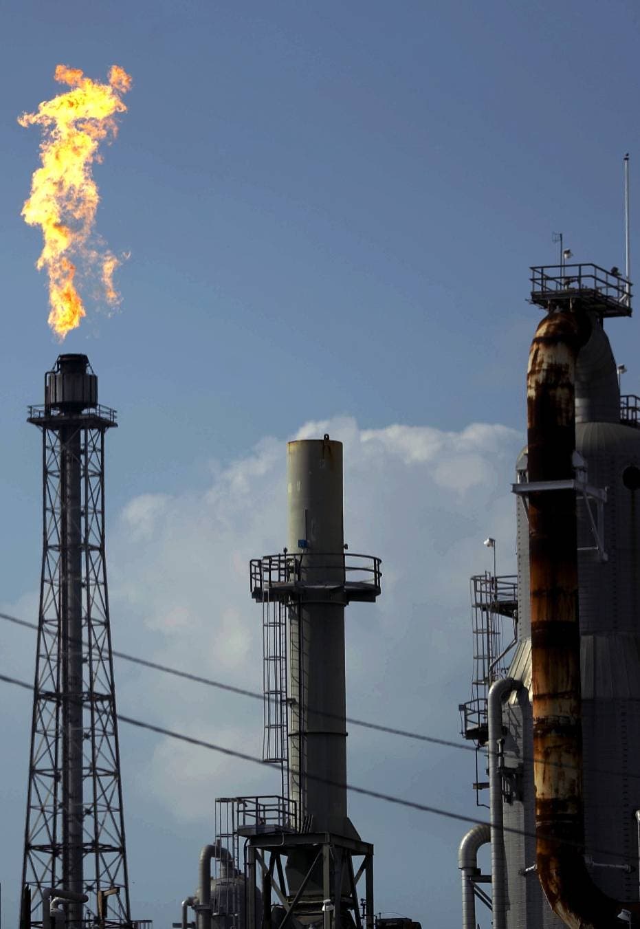 FILE - In this Thursday, Aug. 31, 2017, file photo, a flame burns at the Shell Deer Park oil refinery in Deer Park, Texas. Oil prices are plunging Sunday, March 8, 2020, amid worries that an OPEC dispute will lead a virus-weakened economy to be awash in an oversupply of crude. (AP Photo/Gregory Bull, File)