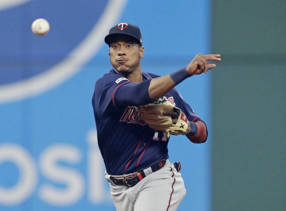 Minnesota Twins' Jorge Polanco throws to first but not in time to get Cleveland Indians' Carlos Santana during the sixth inning of a baseball game Thursday, June 6, 2019, in Cleveland. Polanco was charged with a throwing error. (AP Photo/Tony Dejak)