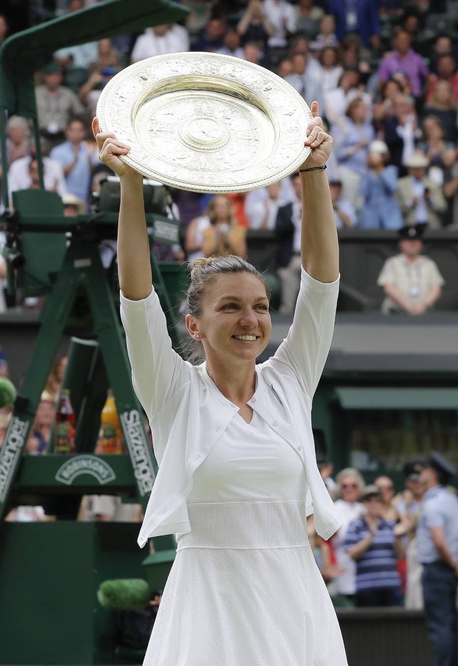 FILE - In this Saturday, July 13, 2019 file photo, Romania's Simona Halep holds up the trophy after defeating United States' Serena Williams in the women's singles final match at the Wimbledon Tennis Championships in London.  Wimbledon has been canceled for the first time since World War II because of the coronavirus pandemic. The All England Club announced after an emergency meeting that the oldest Grand Slam tournament in tennis would not be held in 2020. (AP Photo/Kirsty Wigglesworth, File)