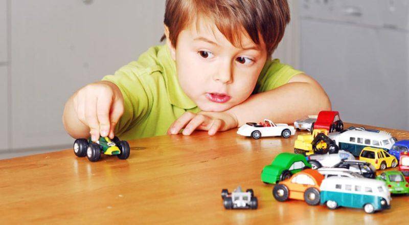 Niño con sus carros de juguete