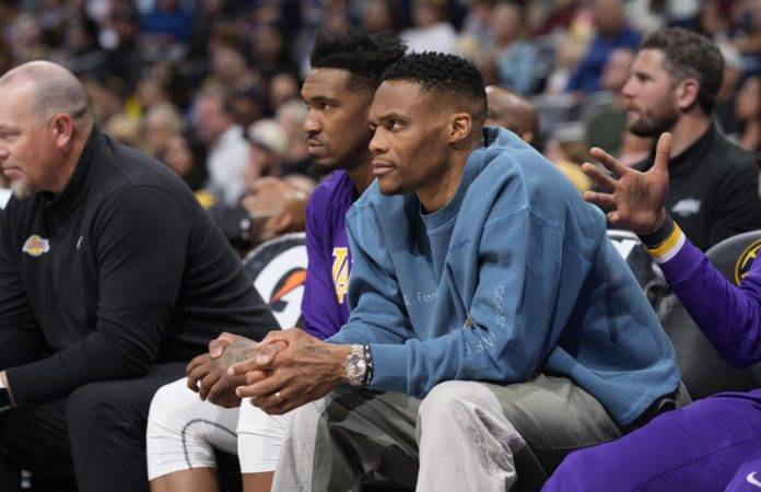 Los jugadores de los Lakers de Los Ángeles Russell Westbrook, al frente, y Malik Monk miran desde la banca en la primera mitad del juego de baloncesto de los Lakers contra los Nuggets de Denver el domingo 10 de abril de 2022 en Denver. (AP Foto/David Zalubowski)
