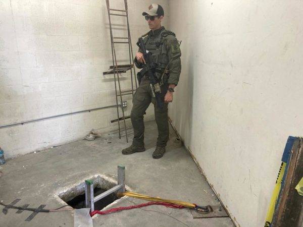 Un agente policial vigila la entrada de un túnel transfronterizo el lunes 16 de mayo de 2022, el cual se extiende desde la ciudad mexicana de Tijuana al área de San Diego. (AP Foto/Elliot Spagat)