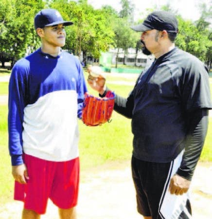 Jose Mesa ofrece consejos a su hijo Jose Ramon joven lanzador.