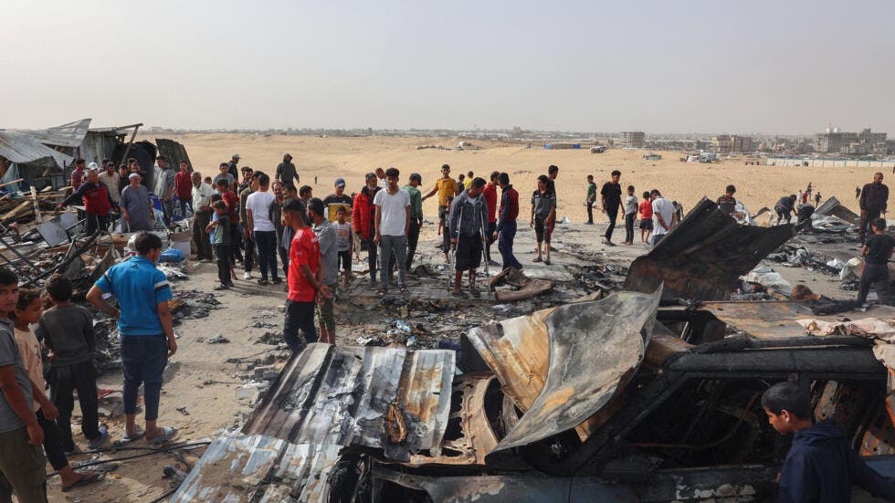 Varios palestinos se reúnen en el lugar de un ataque israelí contra un campo de desplazados internos en Rafah el 27 de mayo de 2024, en medio de los continuos enfrentamientos entre Israel y el grupo terrorista palestino Hamás. AFP - EYAD BABA