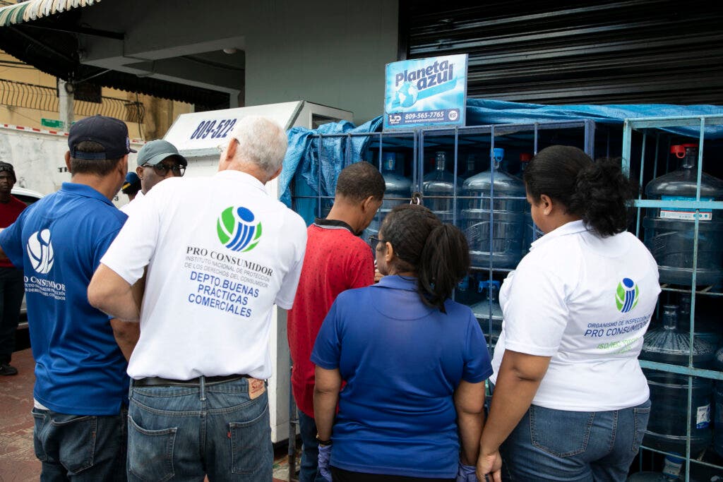 Foto 1 Inspectores de Pro Consumidor en el operativo realizado este lunes en el Distrito Nacional para sacar del mercado los botellones de agua expuestos al sol