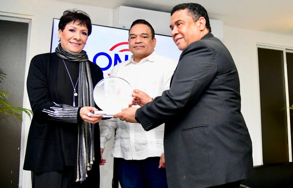 Jose Ruben Gonel Cosme y Armando Olivero entregan la placa de reconocimiento an Sophy